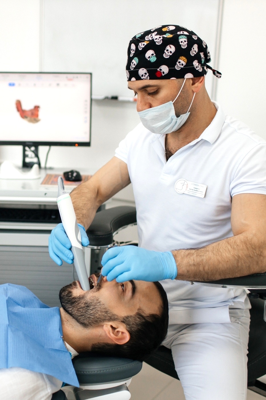 Стоматолог ортопед сканирует зубы пациента для начала проведения протезирования зубов по цифровому протоколу