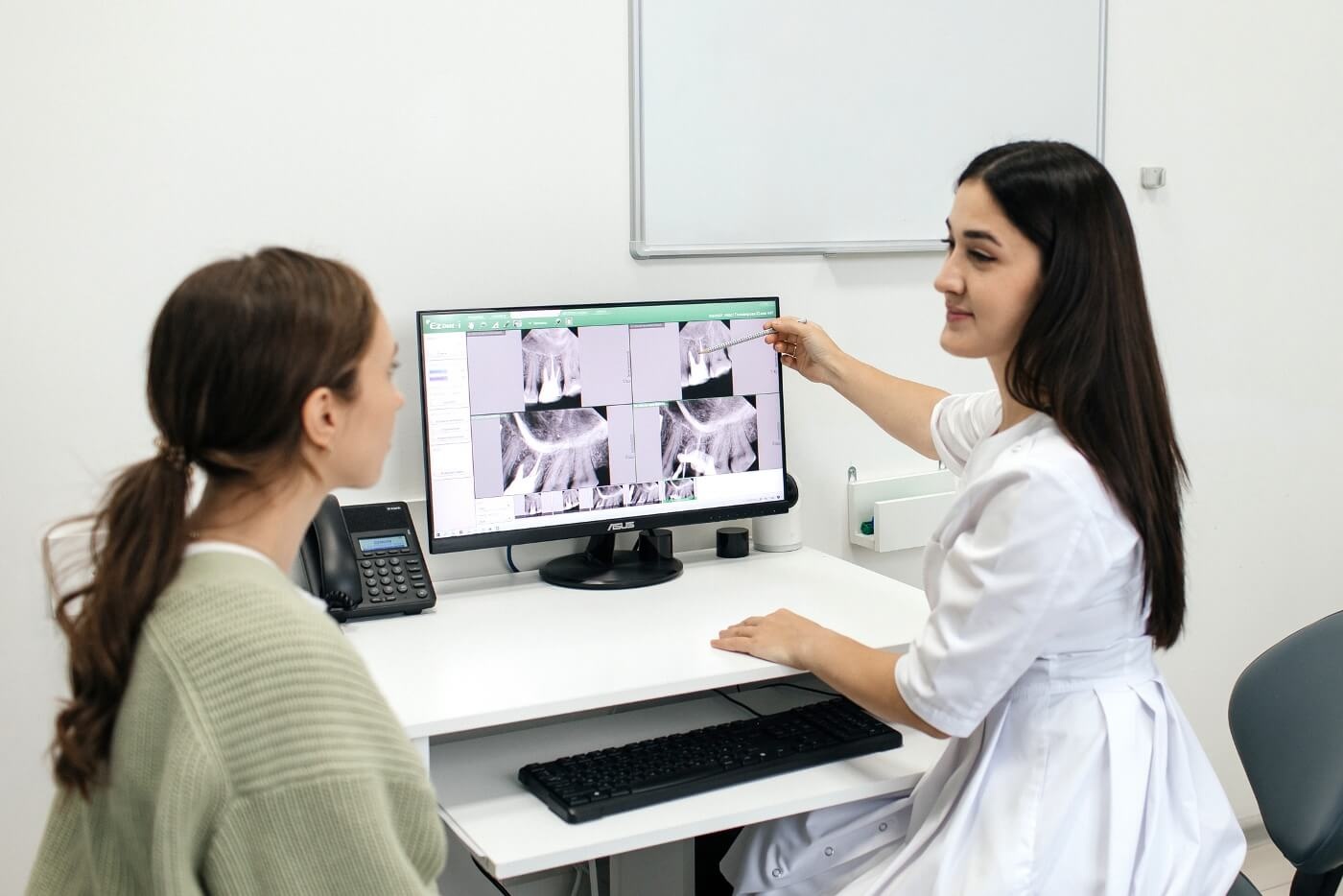 Стоматолог проводит консультацию пациента в клинике Стомион