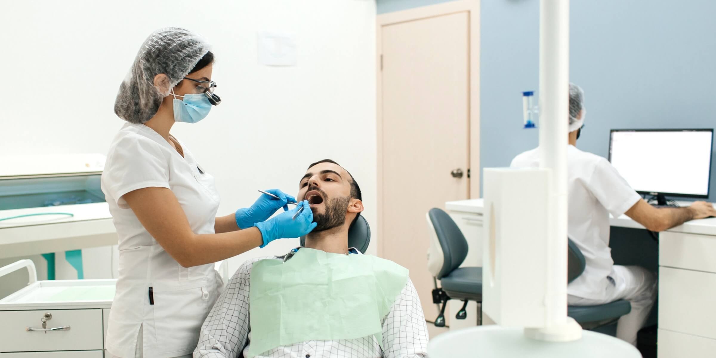 Осмотр пациента перед началом операции по удалению зуба