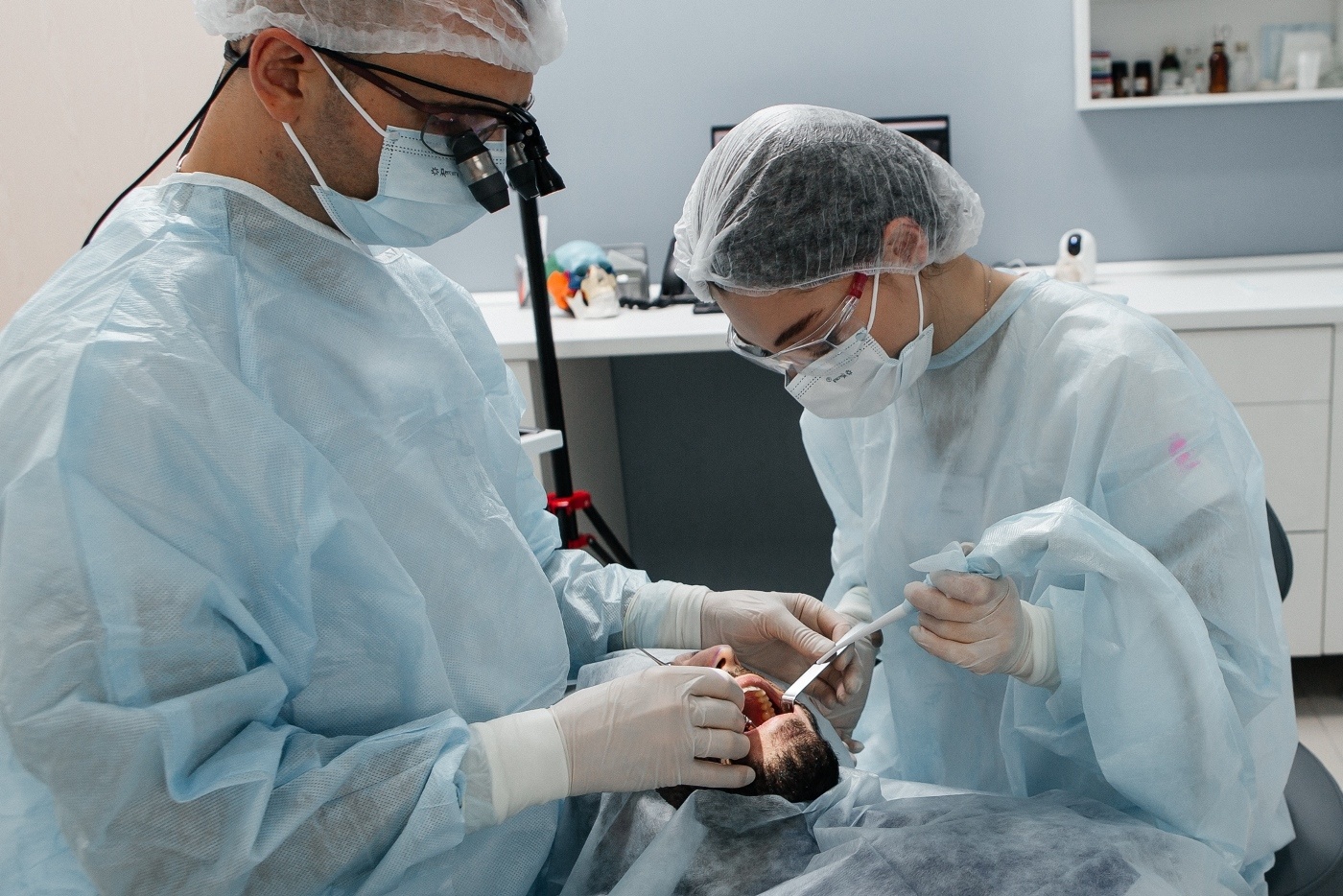 хирург имплантолог стоматологии Стомион проводит операцию по имплантации зубов