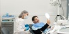 Пациент радуется чистым зубам после профессиональной чистки в стоматологии Стомион