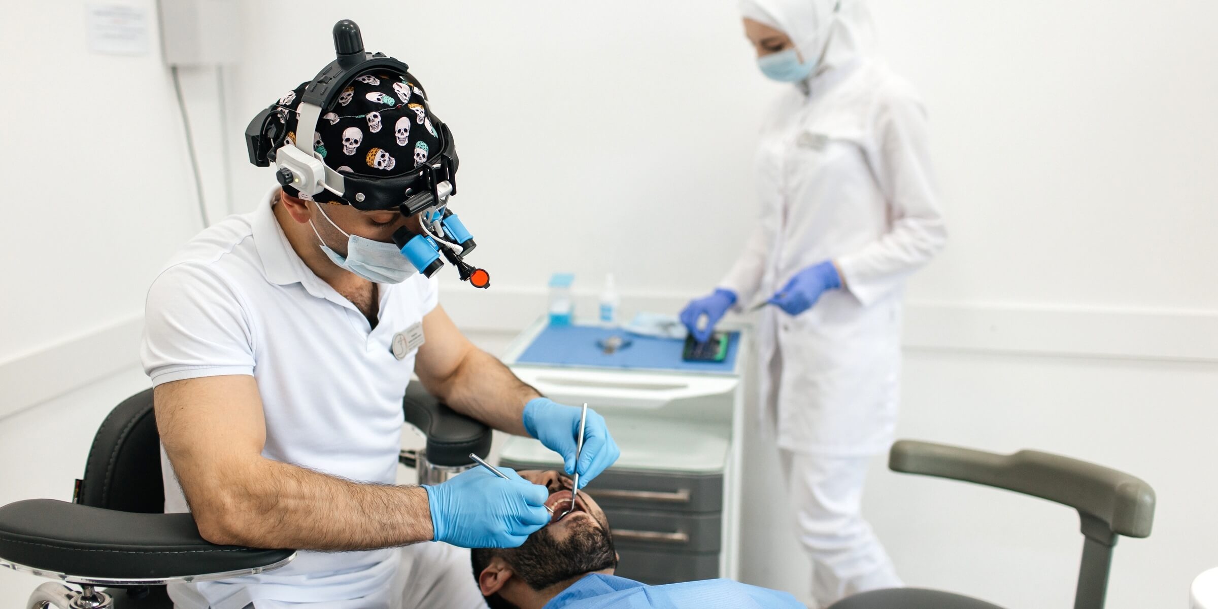 Стоматолог ортопед осматривает полость рта пациента перед началом ортопедического лечения с применением технологий цифровой стоматологии