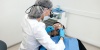 Стоматолог гигиенист проводит профессиональную чистку зубов пациенту